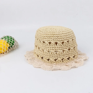 Detailed macro view of beige straw bucket hat with handmade lace trim and crochet hollow mesh