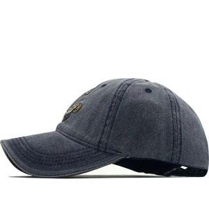Detailed side view of washed navy denim baseball cap featuring yellow embroidery