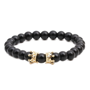 Polished black stone bead bracelet featuring two gold-plated crown charms with micro-diamonds