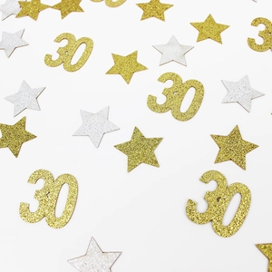 Sparkling gold and silver 30th birthday star confetti scattered on white background