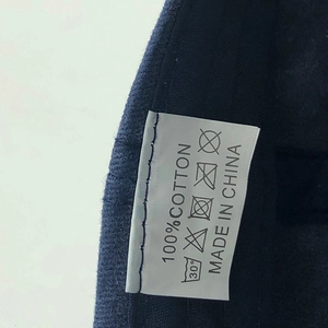 Close-up of 100% cotton wash label on navy blue washed cotton baseball cap details