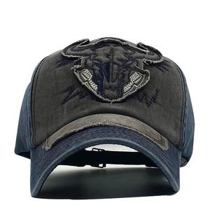 Detail of vintage washed baseball cap featuring a bull skull embroidered patch and frayed edges