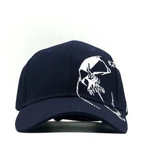 Close-up of white skull embroidery on navy blue cotton twill baseball cap