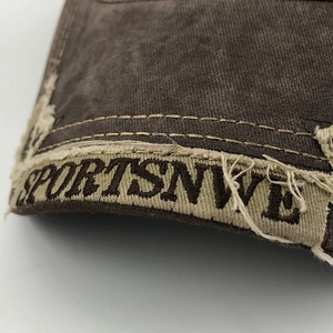 Close-up of vintage washed cotton fabric with distressed edges and SPORTSNWE embroidery