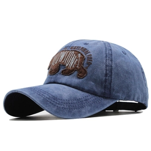 Détail de la broderie d'ours sur une casquette en coton lavé bleu de style vintage