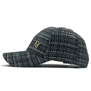 Detail of tweed weave baseball cap with a metallic M buckle and multi-color texture