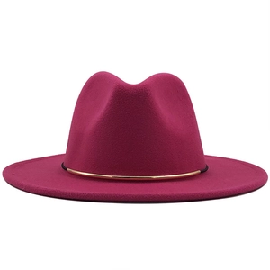Detail of magenta wool fedora hat featuring a decorative gold metallic band accessory