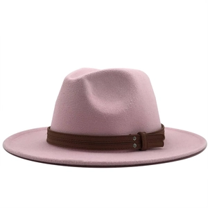 Detail of light pink wool fedora with brown leather band and silver rivet accents
