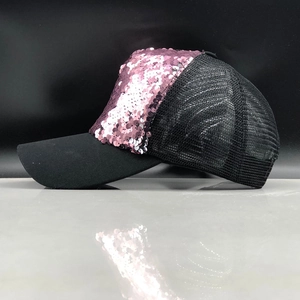 Side view of a pink sequin mesh baseball cap with black curved brim and breathable back
