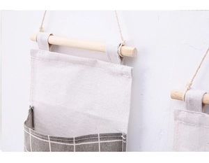 Detailed close-up of cotton linen wall storage bag with wooden bar and gray grid pattern