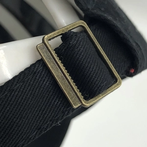 Macro detail of high-density cotton twill strap and vintage bronze metal adjustment buckle