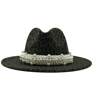Macro detail of leopard print wool fedora featuring luxury white pearl embellishment