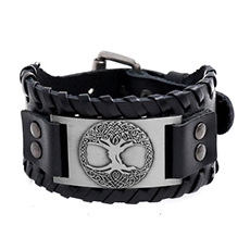 Detail of wide black leather bracelet with woven edges and Tree of Life metal plaque