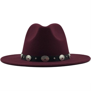 Close-up of wine red fedora hat with black leather belt and vintage metal studs