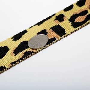 Detail of leopard print wide adjustable shoulder strap with coin for size reference