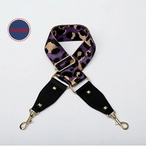 Detail of purple leopard print bag strap with golden metal hardware and swivel hooks