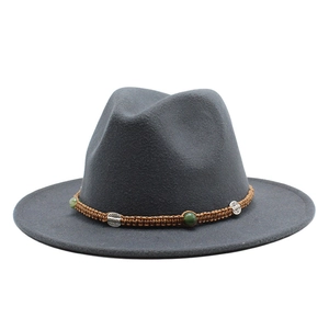 Detail of grey wool fedora hat featuring brown braided cord with green beads and silver accents