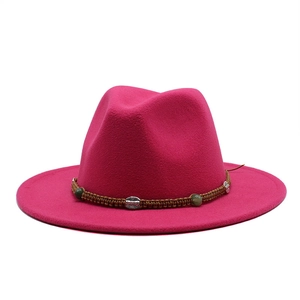 Close-up of fuchsia wool fedora with brown braided band and ethnic style metallic charms