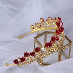 Detailed view of red rose tiara with sparkling rhinestones on a glass display box