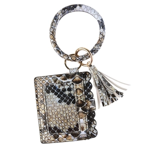Detail of snake print card holder with round wristlet and tassel in gold metal