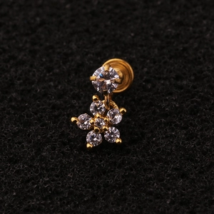 Macro shot of gold zircon flower stud earring with screw back on black textured background
