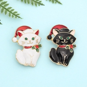 Christmas black and white cat brooches with red hats and green gemstone accents