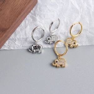 Détail de boucles d'oreilles éléphant en argent et or avec des pierres de zircone