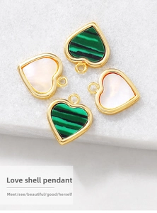 Close-up of heart-shaped pendants in mother of pearl and malachite with gold trim