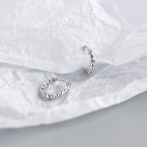 Detail of S925 sterling silver beaded hoop earrings featuring delicate round diamond accents