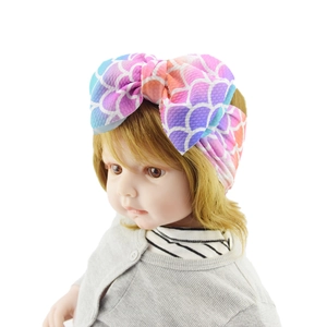 Detail of baby headband with rainbow mermaid scale print and large fabric bow knot
