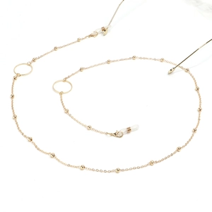 Close-up of golden glasses chain with metal ring accents and silicone connectors