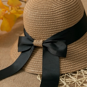 Macro shot of natural woven straw texture with a decorative black ribbon bow detail