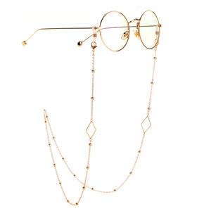 Detail of golden glasses chain with triangular geometric charms and round beads
