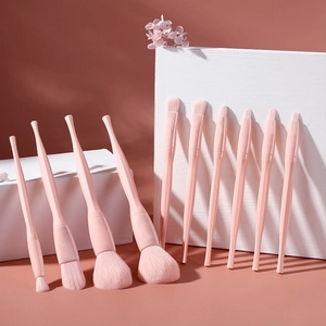 Detail of 12-piece soft pink makeup brush set with faceted handles and fluffy bristles