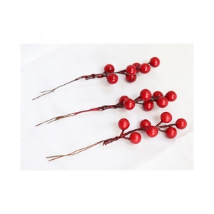 Three realistic red artificial berry stems for Christmas DIY floral decor on white fabric
