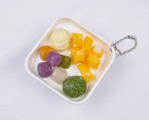 Macro shot of 3D PVC mini dessert bowl keychain with realistic taro balls and mango