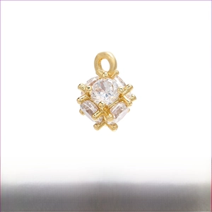 Dettaglio macro del ciondolo sferico in ottone dorato con micro-pavé di zirconi, 6mm