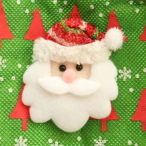 Handcrafted Santa Claus hanging decoration on festive green patterned fabric background