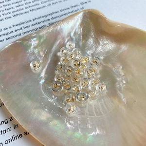 Macro shot of 925 silver core silicone earring backs on a pearlescent shell background