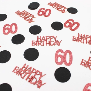 Macro shot of rose gold glitter 60th Happy Birthday confetti and black paper dots
