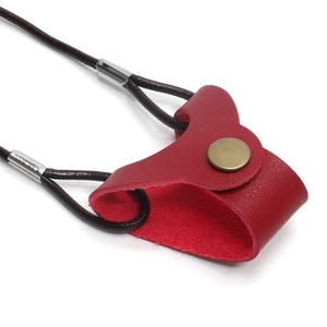 Macro view of red leather sunglasses holder with gold snap and dark brown cord