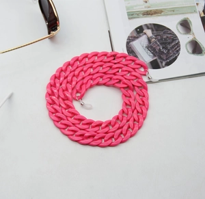 Close-up of pink acrylic eyewear chain with glossy oversized links on white surface