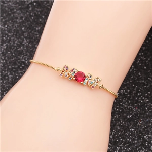 Gold MOM bracelet with pavé colorful zircon and center red gemstone on model wrist