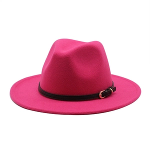 Detail of rose red fedora hat with black leather band and golden metal buckle accessory