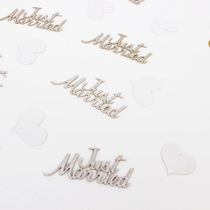 Detail of wooden Just Married lettering and white heart sequins for wedding party decor