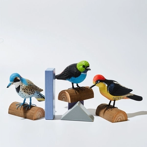 Vue détaillée de trois figurines d'oiseaux en bois sculpté sur petits socles en bois