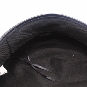 Detail of PU leather peak and internal adjustable drawstring on the black sailor hat