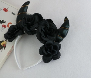 Detail view of black devil horns headband with roses and gold spiral for Halloween