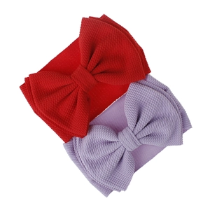 Detail of red and purple waffle texture fabric baby headbands with oversized bows