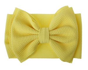 Detail of baby yellow headband showing the textured waffle fabric and large bow